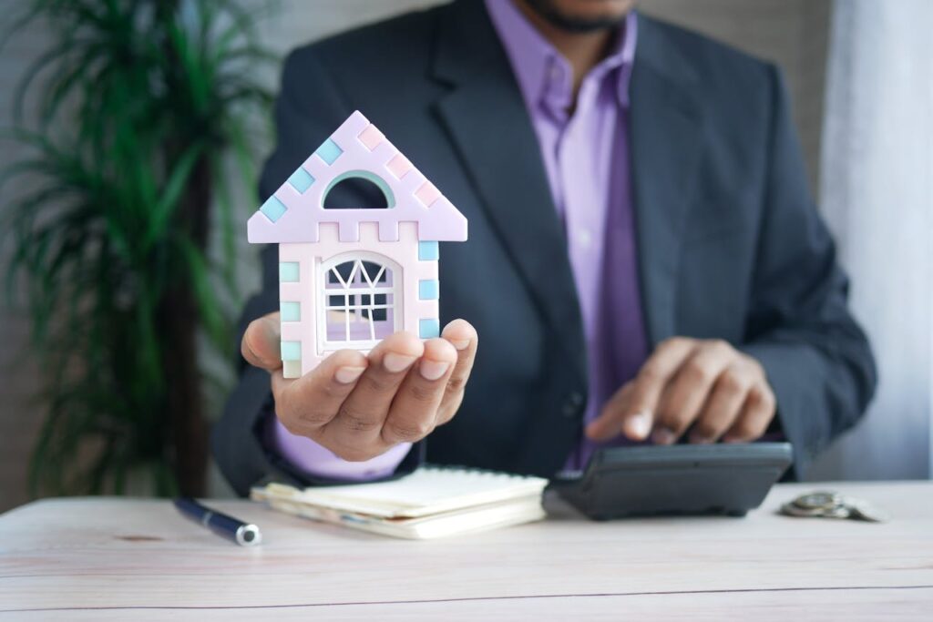 A Person Holding a Model House